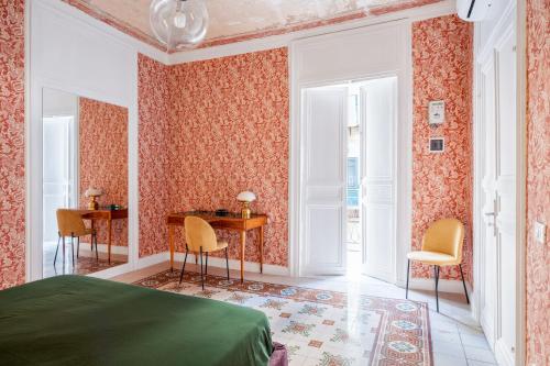 a bedroom with a bed and a desk and chairs at 124 Maqueda Apartments in Palermo