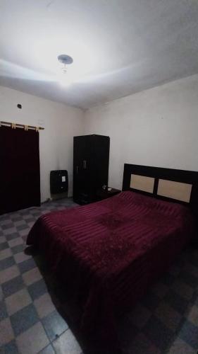 Hostel la abuela في La Unión: غرفة نوم بسرير احمر كبير في غرفة