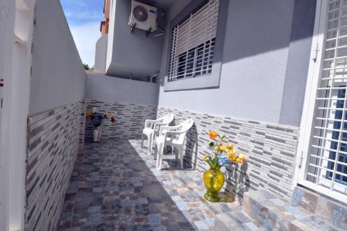 a patio with a vase of flowers on a building at beautiful apartment by the beach in Saïdia