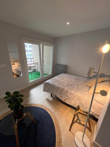 1 dormitorio con cama, mesa y ventana en Apartamento Cué en Gijón