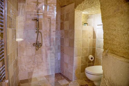 a bathroom with a shower and a toilet in it at Gibos Cave Hotel in Urgup