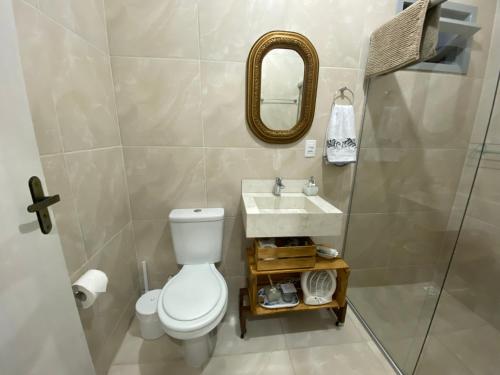 uma casa de banho com um WC, um lavatório e um espelho. em Chalé Terra Luni em Urubici
