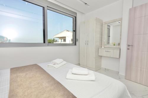 a white bedroom with a bed and a window at NESI Apartments in Ulcinj