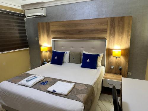 a hotel room with a large bed with blue pillows at Hôtel Esma Nouadhibou in Nouadhibou