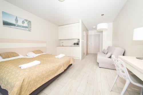 Habitación blanca con cama y escritorio en VacationClub - Ischgl Apartament 19, en Sienna