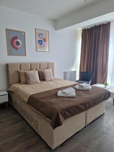 - une chambre avec un grand lit et 2 serviettes dans l'établissement Kamche apartment, à Skopje