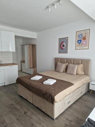 - une chambre avec un grand lit et 2 serviettes dans l'établissement Kamche apartment, à Skopje