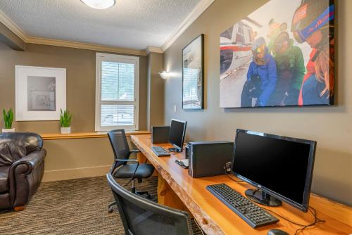an office with a desk with two computers on it at Regent Hotel Revelstoke in Revelstoke