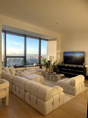 a living room with a large white couch and a flat screen tv at Luxury Highrise Condo Downtown LA in Los Angeles