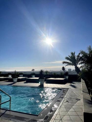 a swimming pool with the sun in the sky at Luxury Highrise Condo Downtown LA in Los Angeles