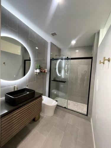 a bathroom with a sink and a toilet and a mirror at Luxury Highrise Condo Downtown LA in Los Angeles