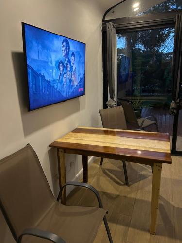 a living room with a table and a tv on the wall at Pyramid Tamarindo Luxury Hotel in Tamarindo