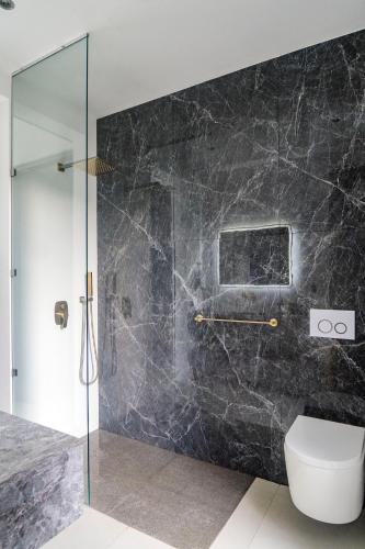 a bathroom with a glass shower and a toilet at KUNUK- Walk to Hermosa beach in Santa Teresa Beach
