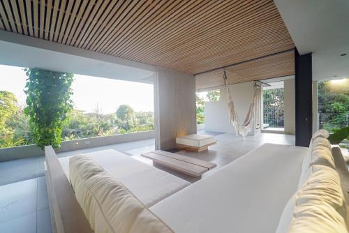 a living room with a couch and a large window at KUNUK- Walk to Hermosa beach in Santa Teresa Beach