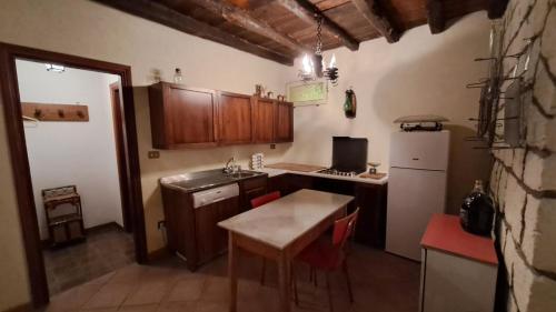 a small kitchen with a table and a refrigerator at Villa Tessa in Ronciglione