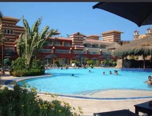 una piscina en un complejo con gente dentro en فندق و سبا بورتو مارينا, en El Alamein