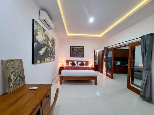 ein Schlafzimmer mit einem Bett und einem Schreibtisch. in der Unterkunft Maha Private Villa in Ubud