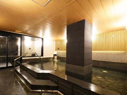 a bathroom with a hot tub in a building at APA Hotel Sapporo Odori Ekimae Minami in Sapporo