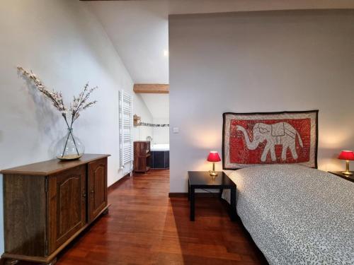 a bedroom with a bed and a vase on a cabinet at La maison des Vendangeurs 10 in Olonzac