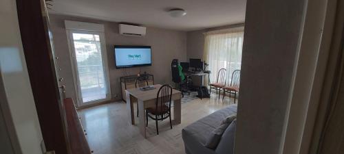 un salon avec une table et une télévision dans l'établissement 70m near Jardin Bonaparte, à Saint-Raphaël