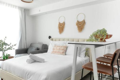 a bedroom with a bed with a table and chairs at דירה בקומפלקס עם בריכה 100 מטר מהים - By Edomlux in Eilat