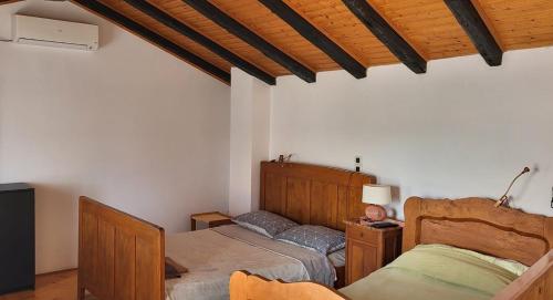 um quarto com 2 camas e um tecto de madeira em Seaside holiday house Unesic - Unije, Losinj - 8045 em Unije