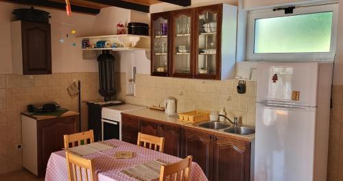 eine Küche mit einem Tisch und einem weißen Kühlschrank in der Unterkunft Seaside holiday house Unesic - Unije, Losinj - 8045 in Unije