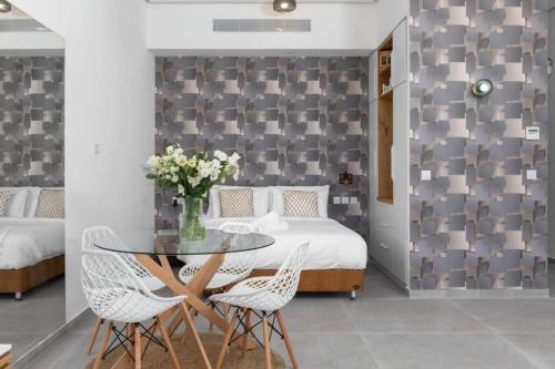 1 dormitorio con mesa, 2 sillas y 1 cama en דירת גן במתחם סי סייד 100 מטר מהים - By Edom, en Eilat