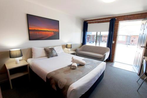 Blue Shades Motel في ماريبورو: غرفة نوم بسرير واريكة وكرسي