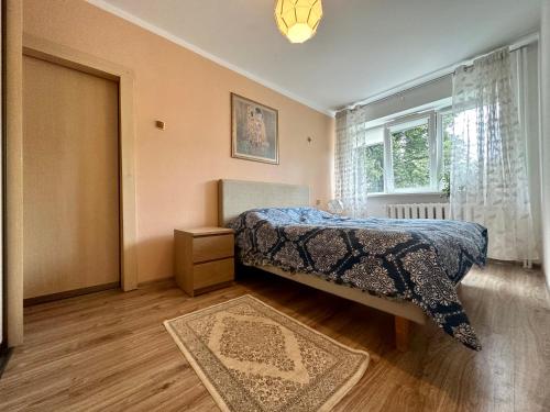 een slaapkamer met een bed en een raam bij Riga Mezaparks Apartment in Rīga