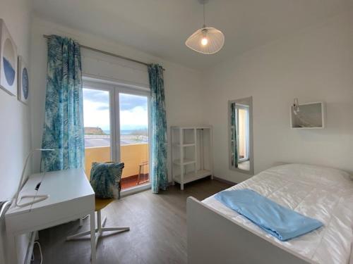 a bedroom with a bed and a desk and a window at Casa da Formosa in Silveira