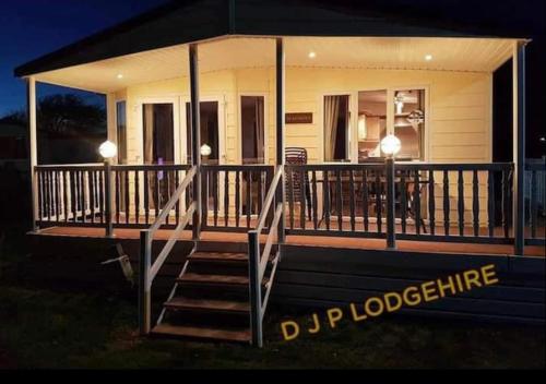 a house with a large deck with two lights on it at Lodge for Hire in Pagham