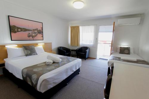 Habitación de hotel con 2 camas y escritorio en Blue Shades Motel en Maryborough