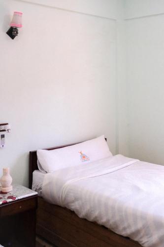 a bed in a room with a white wall at Al-Manara Hostel Siwa Oasis in Siwa