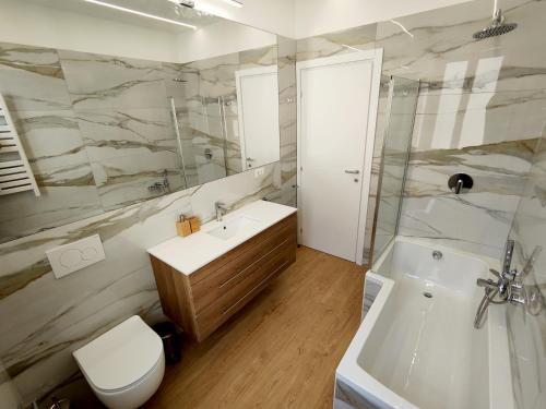 e bagno con lavandino, servizi igienici e doccia. di Attico Vespucci Luxury Penthouse a Olbia
