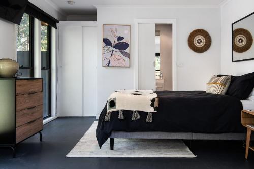 a bedroom with a black bed and white walls at Ablac Studio in Glenlyon