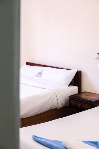 a bedroom with two beds and a nightstand next to a bed at Al-Manara Hostel Siwa Oasis in Siwa