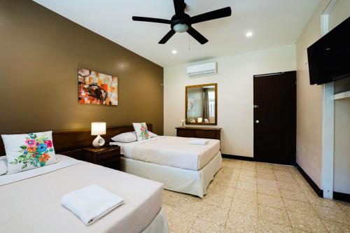 a bedroom with two beds and a ceiling fan at Hotel Diriá Santa Cruz in Santa Cruz