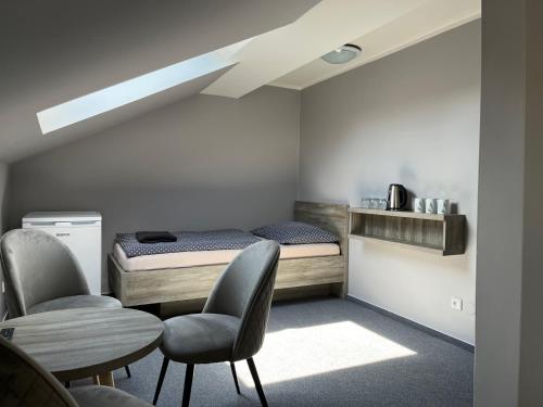 1 Schlafzimmer mit einem Bett, 2 Stühlen und einem Tisch in der Unterkunft Almond in Teplice