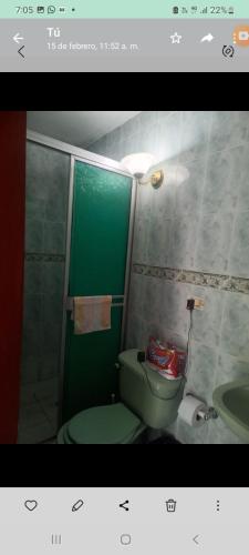 uma casa de banho com um WC verde e um lavatório em Apartamento en avenida sexta de Cali em Cali