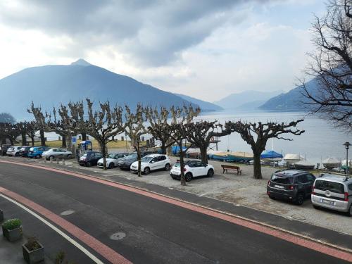 Une rangée de voitures garées dans un parking à côté d'un lac dans l'établissement Meraviglioso appartamento fronte lago, à Bissone