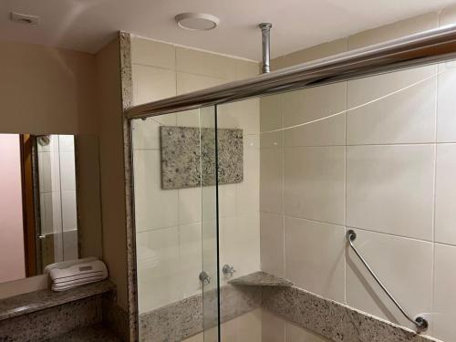 a shower with a glass door in a bathroom at Exclusiva Suíte Granja Brasil in Petrópolis