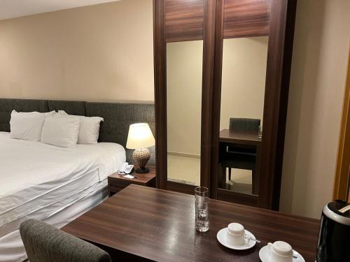 a hotel room with a bed and a wooden table at Exclusiva Suíte Granja Brasil in Petrópolis