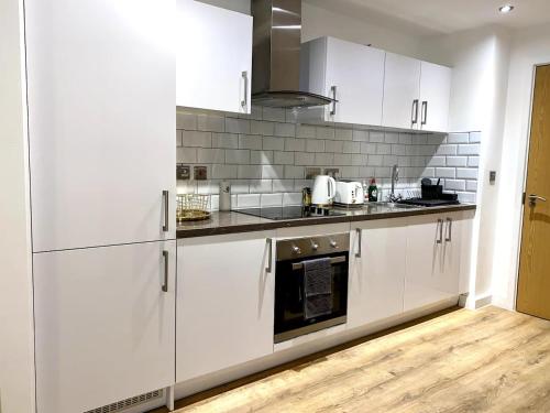 eine weiße Küche mit weißen Schränken und Geräten in der Unterkunft JB Properties in Birmingham