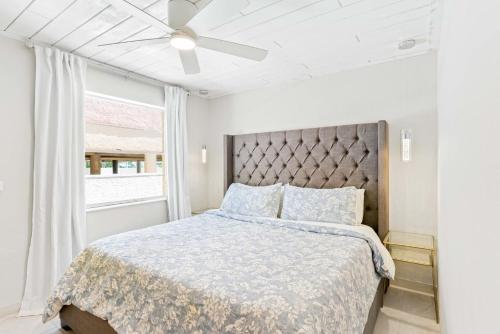 um quarto com uma cama e uma ventoinha de tecto em Beachside Retreat W Heated Pool em St. Pete Beach