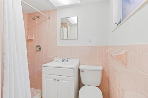 a pink bathroom with a toilet and a sink at Beachside Retreat W Heated Pool in St. Pete Beach