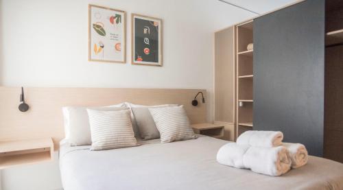 a bedroom with a white bed with towels on it at Grid Suites Charcas in Buenos Aires