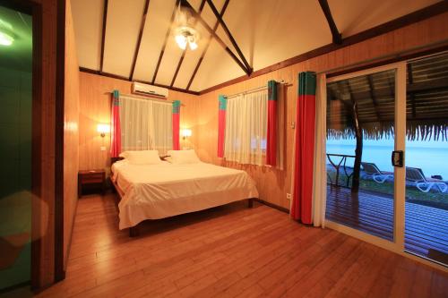 - une chambre avec un lit et une vue sur l'océan dans l'établissement Raira Lagon, à Avatoru