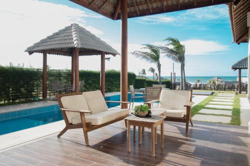 a patio with chairs and a table and a pool at Illa Blue Village in Trairi