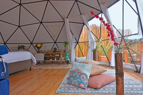 Un dormitorio con una tienda de campaña con una cama y un jarrón de flores en Glamping Claro de Luna, en Guatavita